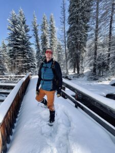 Photo of Max Wilding on a pile of snow in wood.